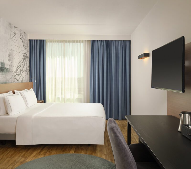 Wide angle of superior queen room with tv and desk